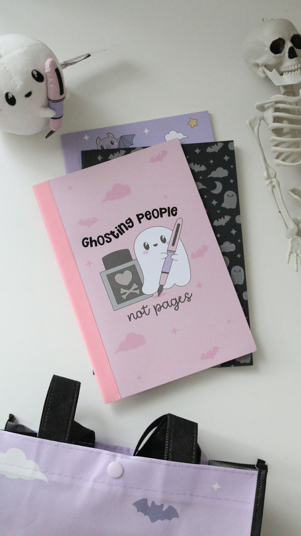 Pink Ghosting People notebook with the black notebook
